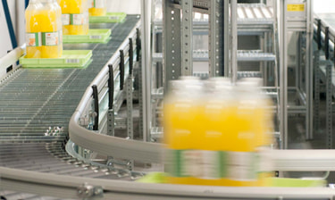 Orangensaft auf dem Fliessband Succo d’arancia su nastro trasportatore